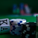 Close-up of playing cards and poker chips on a green felt table